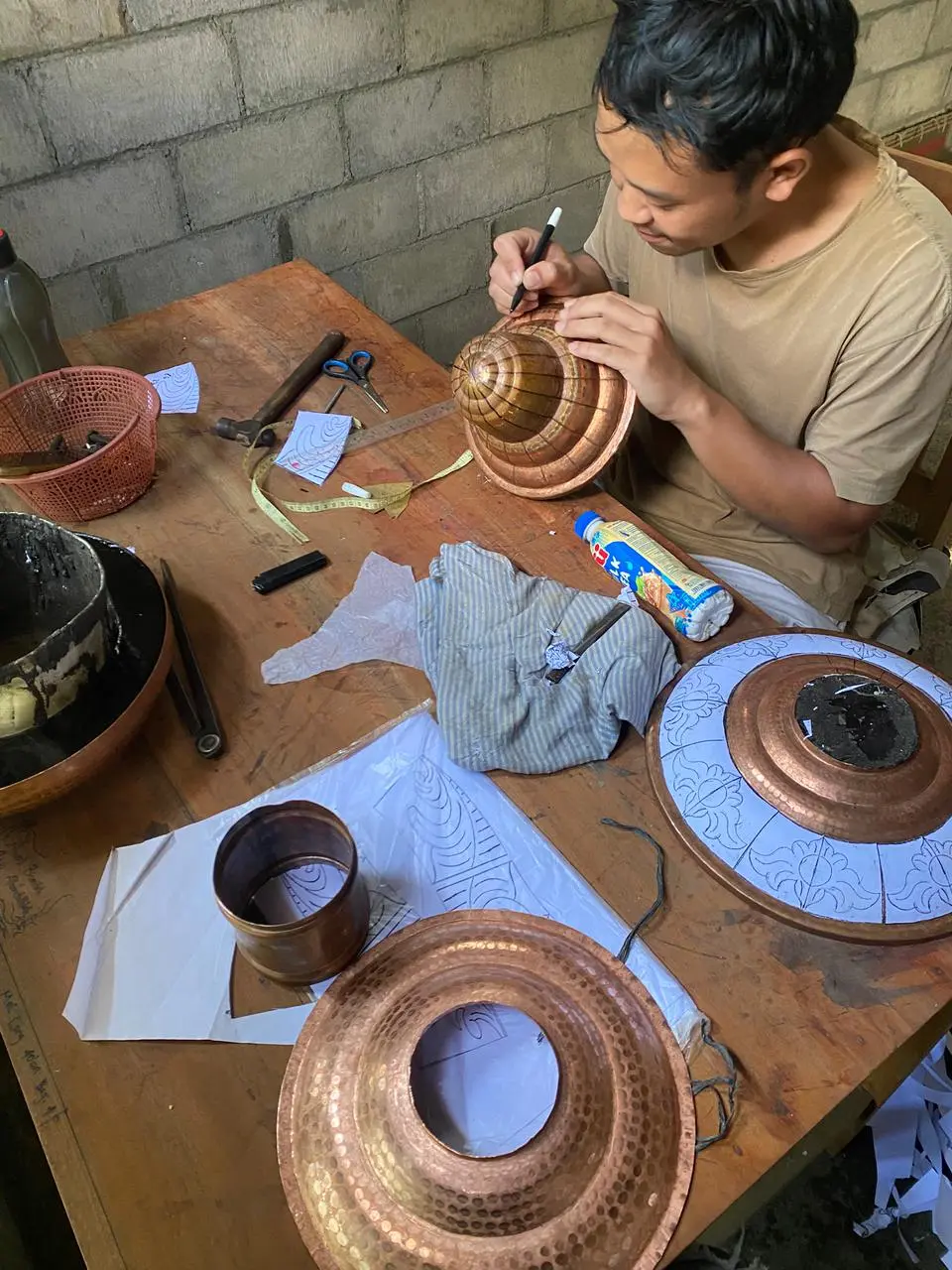 Pengrajin Ragam Tembaga sedang mengukir lampu hias tembaga berkualitas tinggi